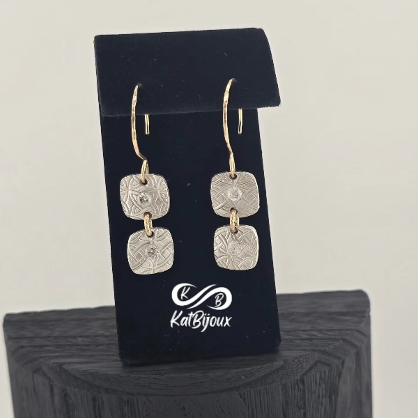 Silver double cushion drop earrings with stones and gold accents.